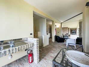 A modern kitchen with a stone backsplash, a fire extinguisher, and a glass-top table. - Vacation home Vidal by Interhome (Spoltore)