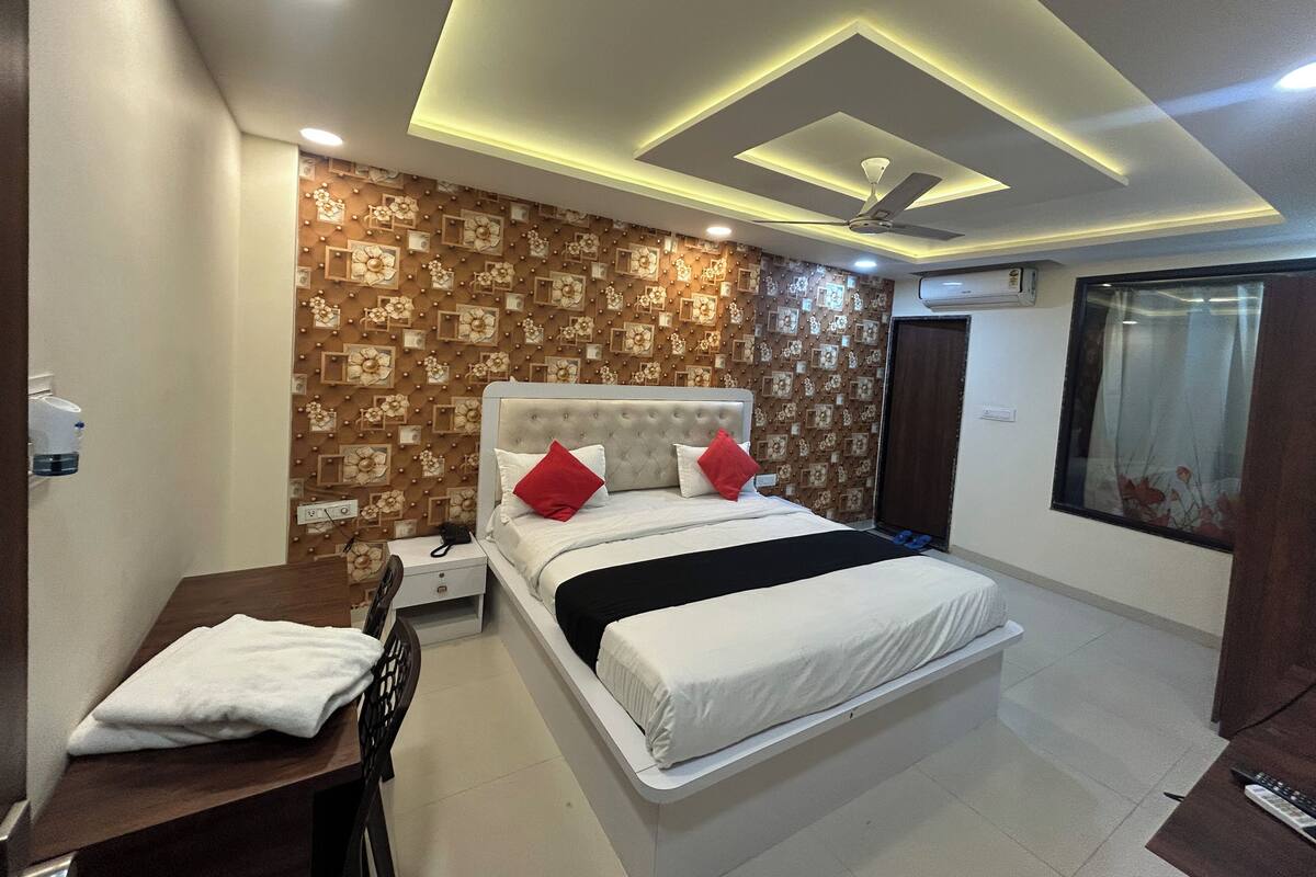 A bedroom with a bed, bedside table, and a desk.