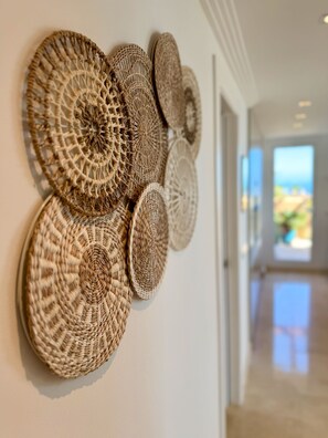 A wall with a series of woven circular wall hangings.