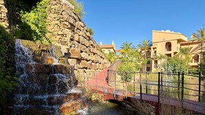 Ein Wasserfall, eine Brücke und Gebäude im Hintergrund.