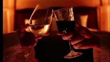 Due mani che sorreggono bicchieri da vino.