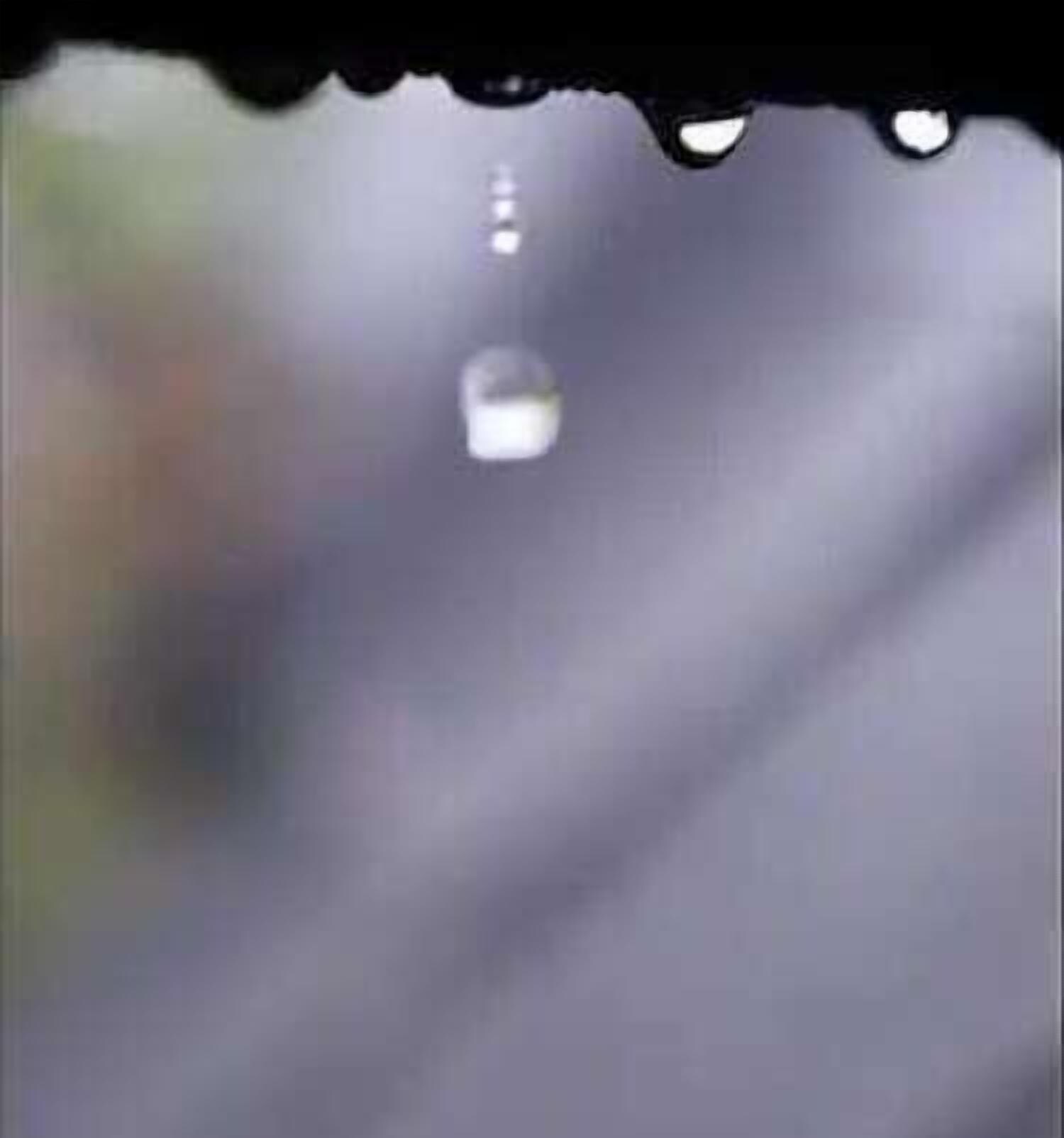 A blurred background with a single water droplet in focus.