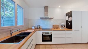A modern kitchen with a large window, a built-in oven, and a refrigerator. - Les Mouettes by Interhome (Soustons)