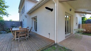 A house with a patio, a wooden table, and chairs. - Les Mouettes by Interhome (Soustons)