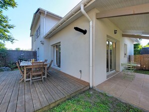 A house with a patio, a wooden table, and chairs. - Les Mouettes by Interhome (Soustons)