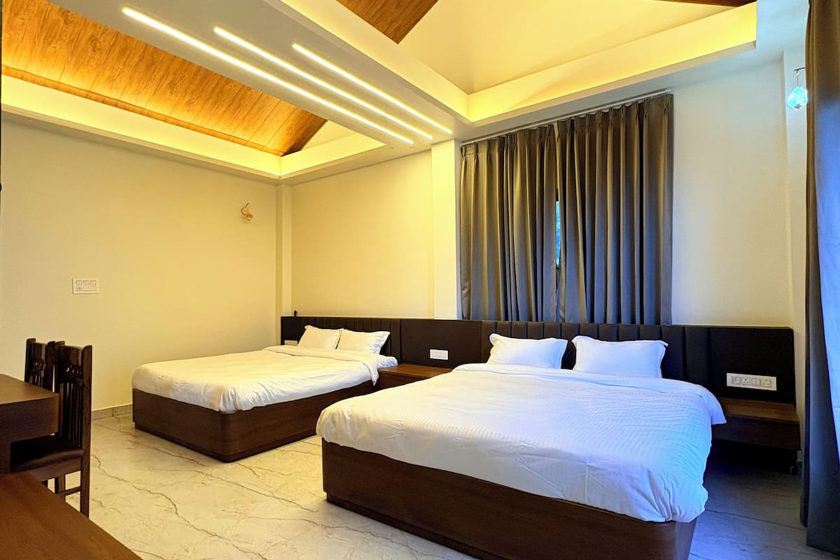 Habitación de hotel con dos camas, techo de madera y suelo de mármol.
