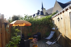 A wooden deck with a patio chair, a lounge chair, and a potted plant. - Studio with terrace Port de St Goustan (Auray)