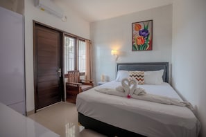 A hotel room with a bed, a chair, a wall-mounted lamp, and a door. - Cedil Private 3BR Pool Villa Seminyak (Kabupaten Badung)