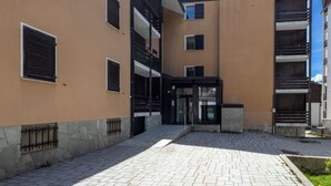 En bygning med flere etager, en central gårdsplads, sten trapper og en jerngitter.