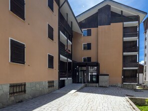 Ein mehrstöckiges Gebäude mit Innenhof, Steintreppe und einem Metallgitter.
