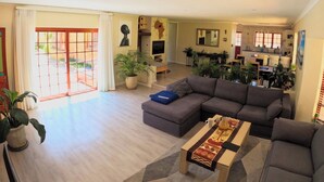 Ein Wohnzimmer mit Sofa, Couchtisch und Topfpflanzen.