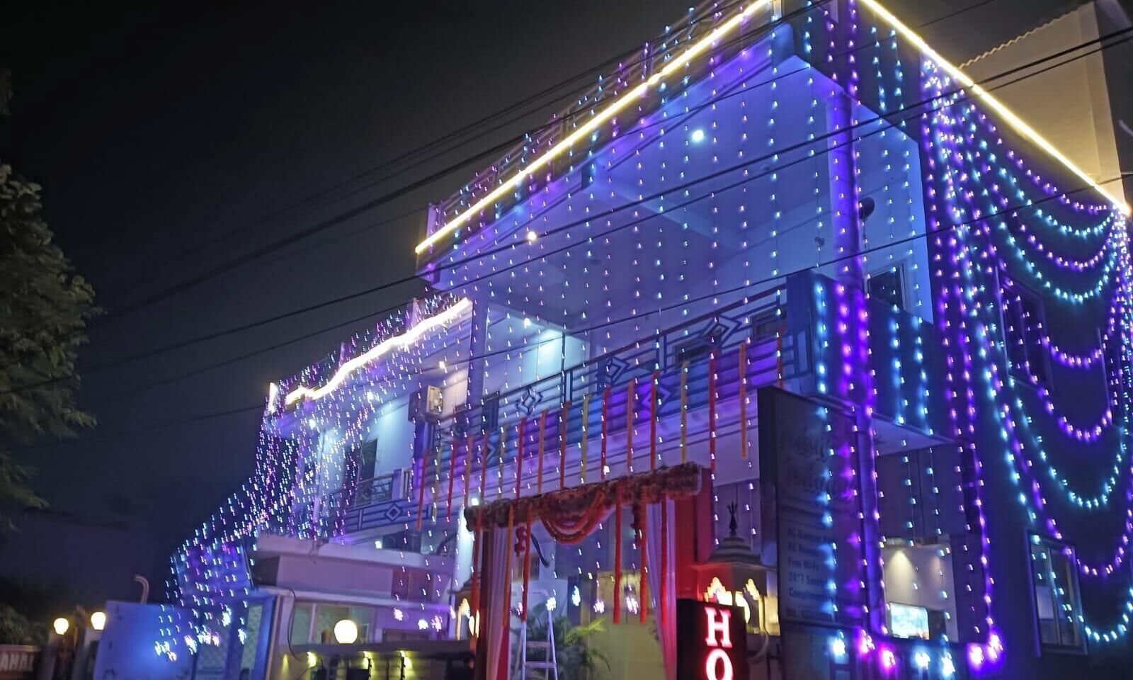 A building with multiple floors, adorned with string lights and draped fabric.