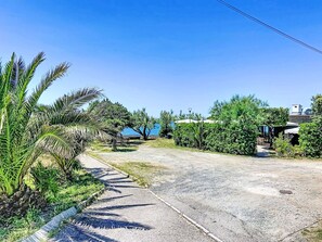 A paved road with a sidewalk, palm trees, and a clear blue sky. - La Tana by Interhome (Castiglioncello)