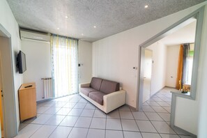 Ein modernes Wohnzimmer mit einer Couch, einem Fernseher und einer Heizung.