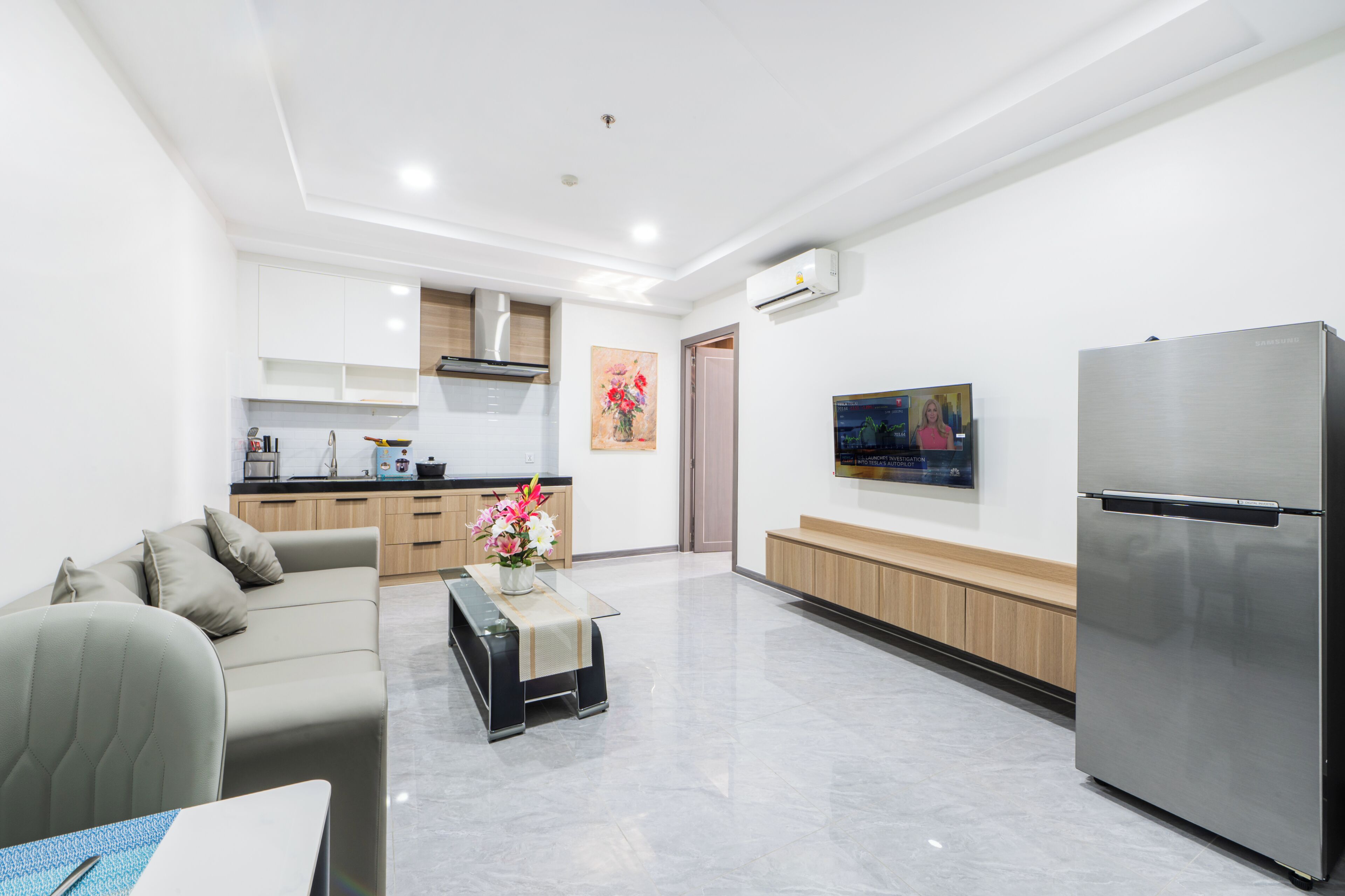 A modern living room with a sofa, a coffee table, and a flat-screen TV.