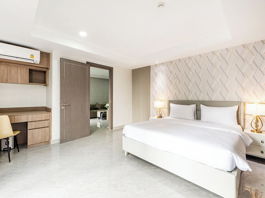 Una habitación de hotel moderna con una cama grande, un escritorio y un armario.