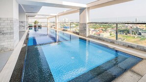 An indoor swimming pool with a view of a cityscape. - H Resident (Phnom Penh)