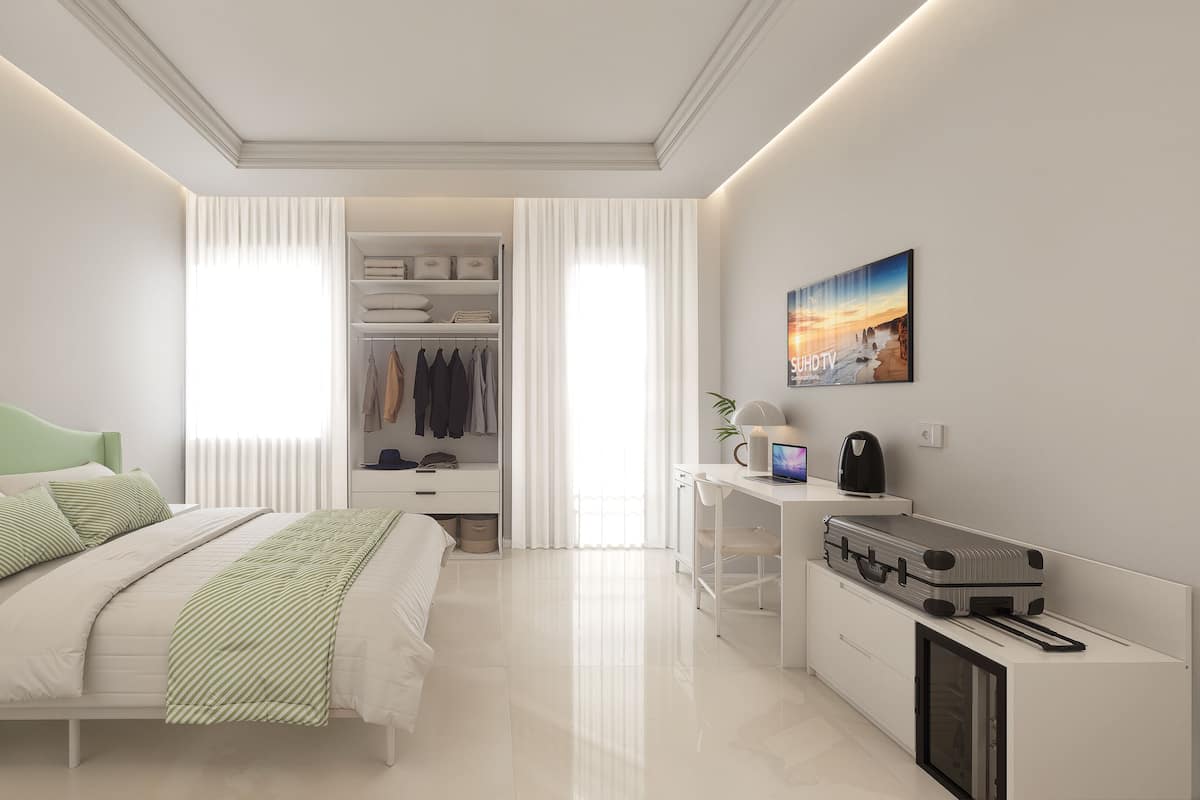 A modern bedroom with a bed, bedside table, desk, and a wardrobe.