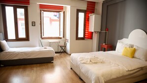 A hotel room with two beds, a small table, a chair, and a window with blinds. - BRK DREAM SUITS (Istanbul)