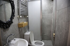 Ein Badezimmer mit Toilette, Waschbecken und Duschbereich.