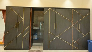 Habitación con un amplio armario que presenta diseños geométricos y detalles dorados.