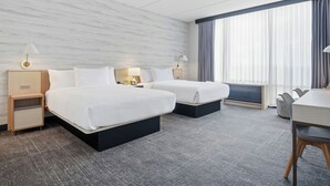 A hotel room with two beds, a desk, and a large window with curtains. - TownePlace Suites by Marriott Vaughan (Vaughan)