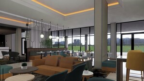 A modern lounge area with sofas, chairs, and tables, large windows with a view of buildings and greenery. - TownePlace Suites by Marriott Vaughan (Vaughan)