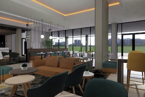 Ein moderner Lounge-Bereich mit Sofas, Sesseln und Tischen, große Fenster mit Blick auf Gebäude und Grünflächen.