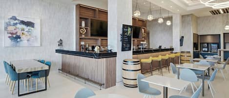 A modern restaurant interior with a bar area, seating arrangements, and a large abstract painting on the wall.