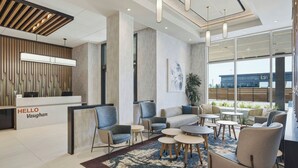 A modern reception area with a 'HELLO Vaughan' sign, seating arrangements, and a large window offering a view of the outside. - TownePlace Suites by Marriott Vaughan (Vaughan)