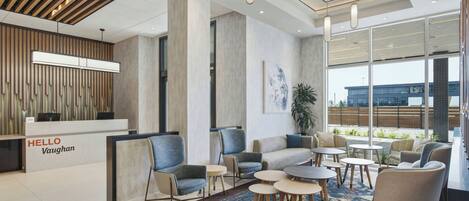 A modern reception area with a 'HELLO Vaughan' sign, seating arrangements, and a large window offering a view of the outside.