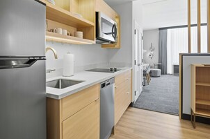 Una cocina moderna con lavavajillas integrado, electrodomésticos de acero inoxidable y muebles de madera.