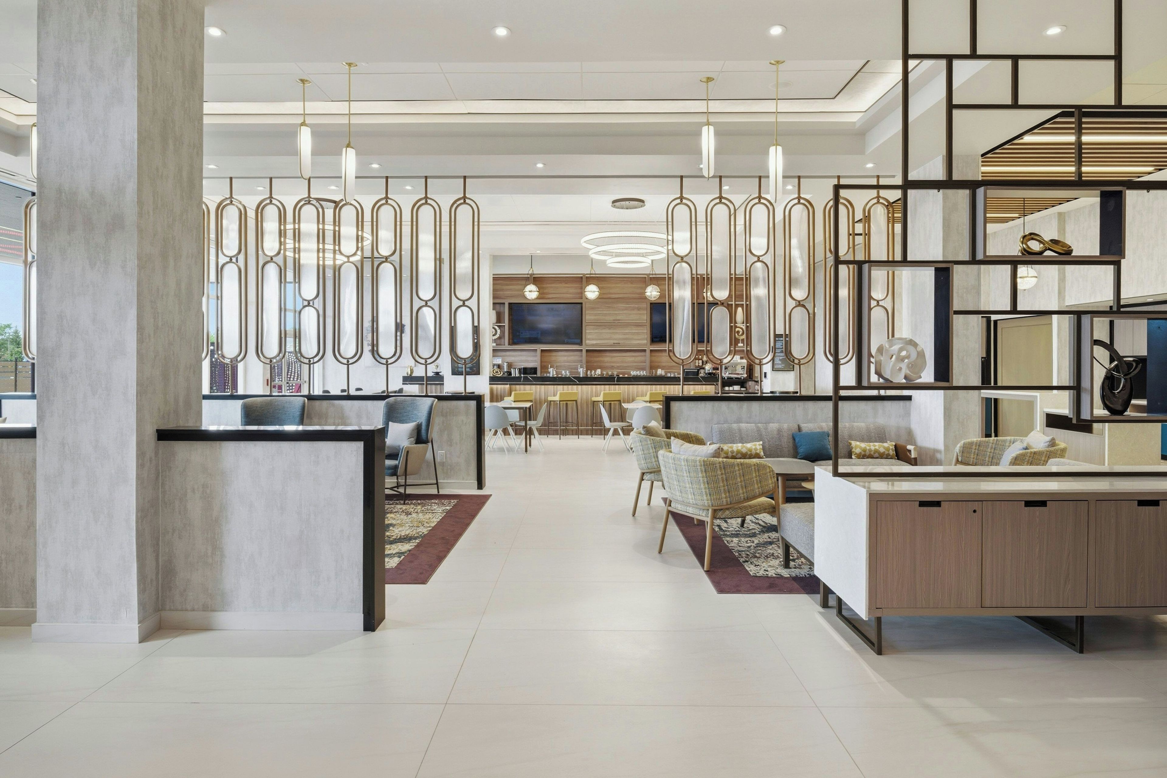 Un intérieur moderne avec un espace salon central, un bar et un coin repas.