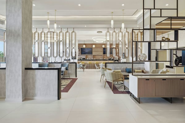A modern interior with a central seating area, a bar, and a dining space.