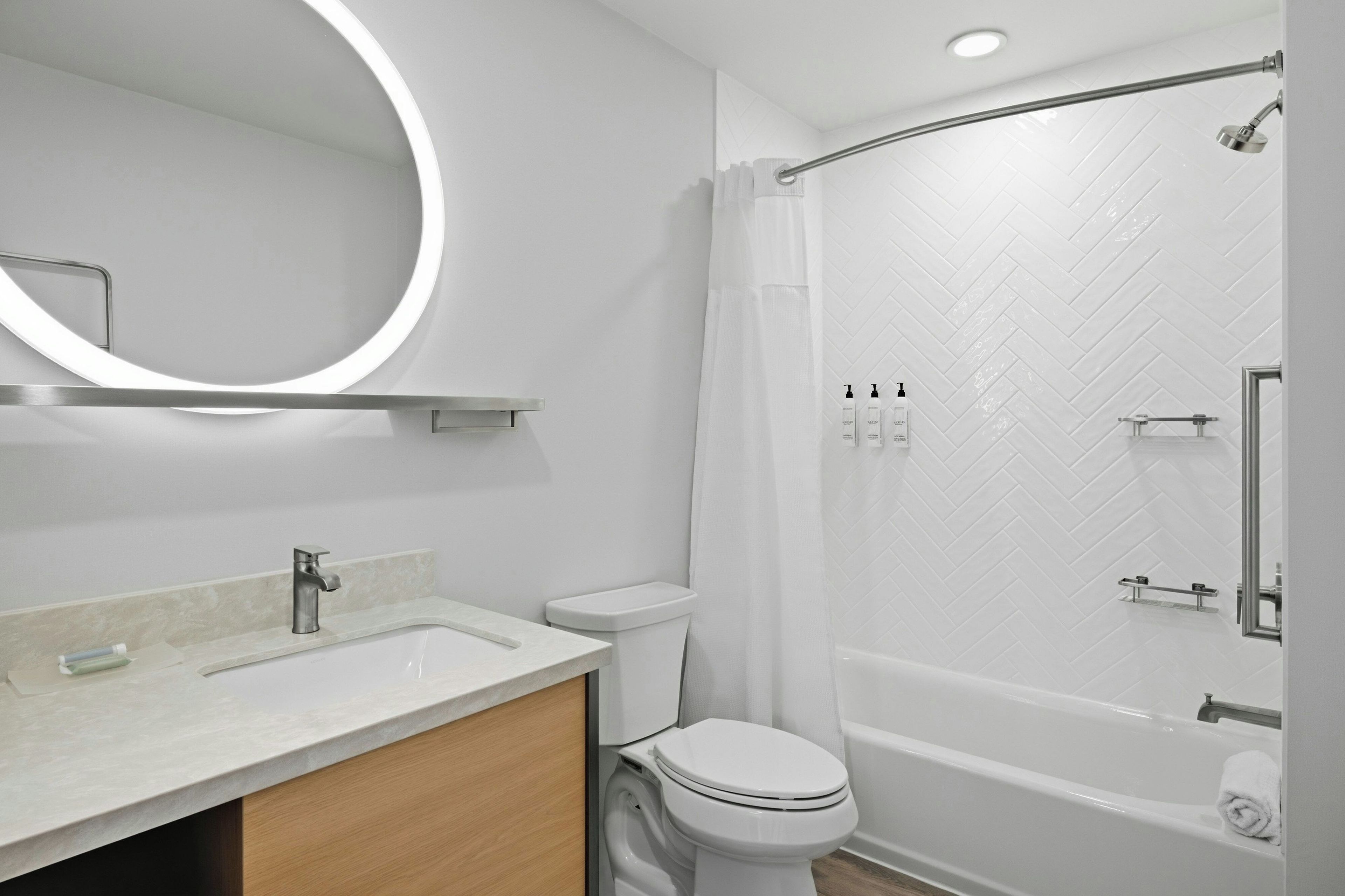 Ein modernes Badezimmer mit Waschbecken, Toilette und Badewanne in Weiß.