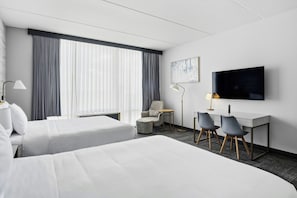 A hotel room with two beds, a desk with two chairs, a TV, and a window with curtains. - TownePlace Suites by Marriott Vaughan (Vaughan)