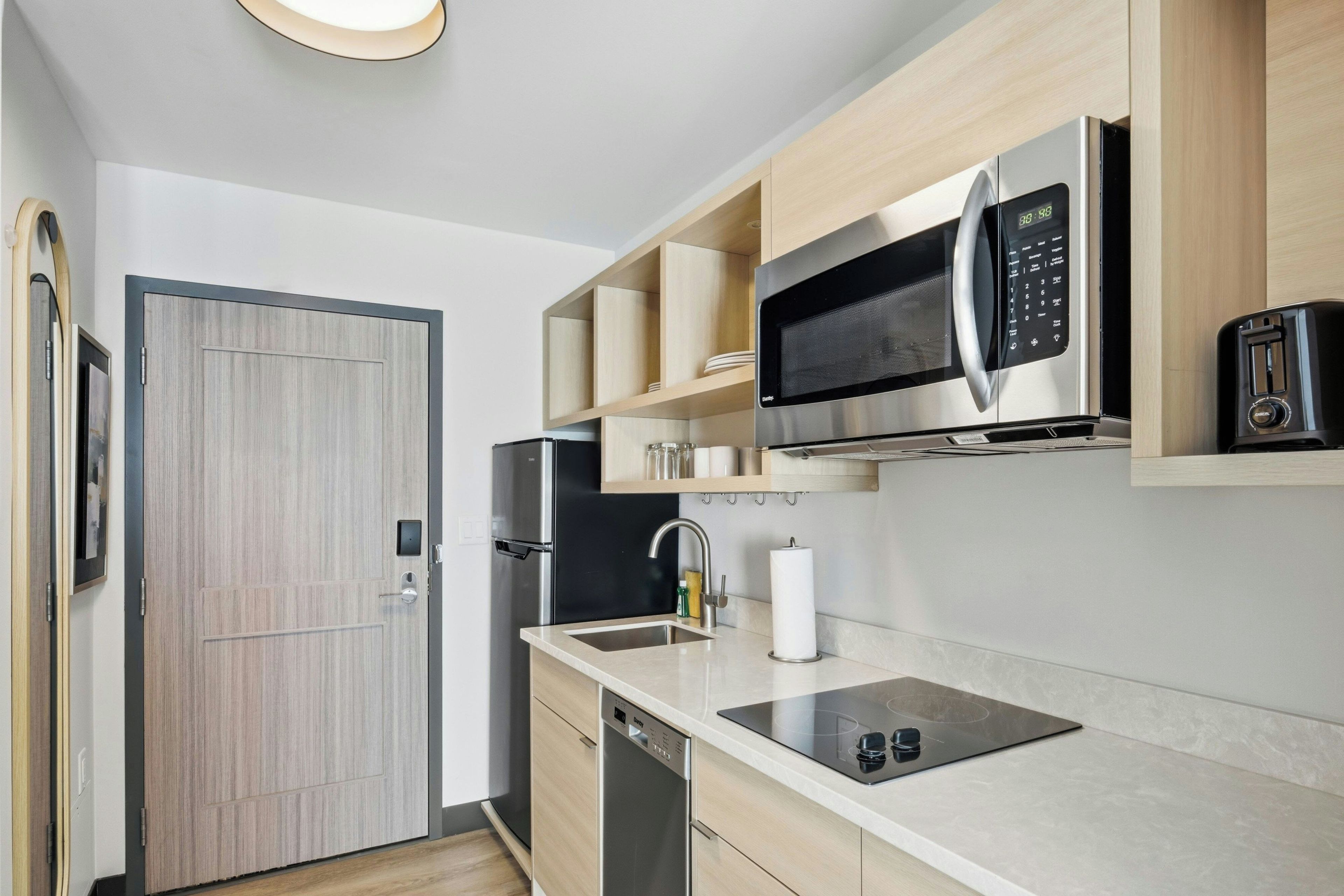 A modern kitchen with a built-in microwave, a dishwasher, and a sink.