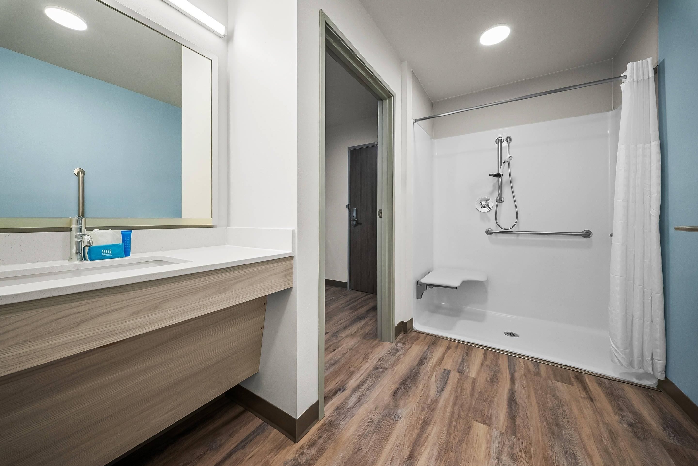 Ein modernes Badezimmer mit Dusche, Waschbecken und Spiegel.