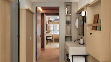 A modern bathroom with a sink, mirror, towel rack, and a shower area.