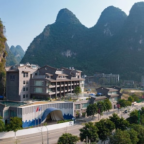 A hotel with a modern design, located near a mountainous area. - TUI Blue Yangshuo Xiangheli Hotel (GUILIN)