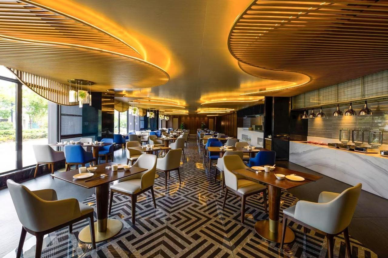 Un interior de restaurante moderno con una barra central, arreglos de asientos y un suelo estampado.