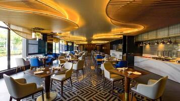 Un interior de restaurante moderno con una barra central, arreglos de asientos y un suelo estampado.