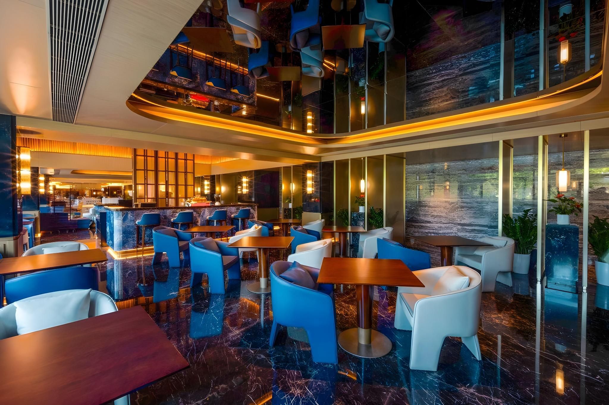 A modern interior with seating areas, a bar, and large windows.