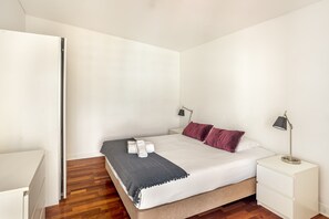 A bedroom with a bed, bedside tables, a wardrobe, and a door. - Downtown Riverside V by Homing (Lisbon)