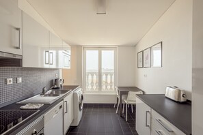 A compact kitchen with a washing machine, a coffee maker, and a toaster. - Downtown Riverside V by Homing (Lisbon)