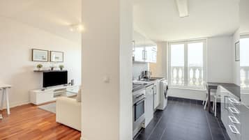 Een modern appartement met woonkamer, keuken en balkon.