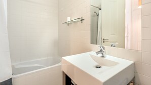 A modern bathroom with a bathtub, a sink, and a mirror. - Downtown Riverside IV by Homing (Lisbon)