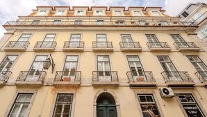 A multi-story building with balconies, a green door, and a sign for 'CYBERCAFE'. - Chiado Deluxe by Homing (Lisbon)