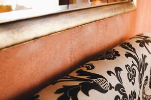 A close-up of a textured wall and a patterned cushion.