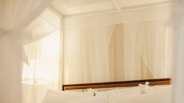 A bed with white linens and a wooden headboard, surrounded by sheer curtains. - Ma' Ca' - La Grigia (Praiano)
